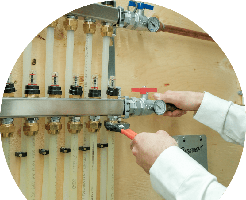 The Comfort Group HVAC specialist performing boiler repair, adjusting internal components of a residential unit with visible copper piping and control wiring. The Comfort Group HVAC specialist performing boiler repair, adjusting internal components of a residential unit with visible copper piping and control wiring.