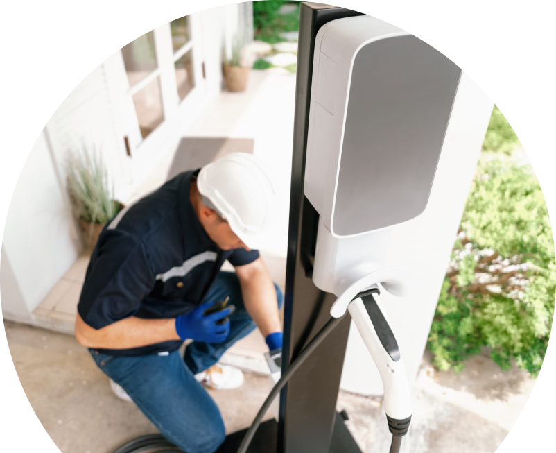 Home service electrician from The Comfort Group installing an EV charger fixed to a vertical post near a residential entryway. Home service electrician from The Comfort Group installing an EV charger fixed to a vertical post near a residential entryway.